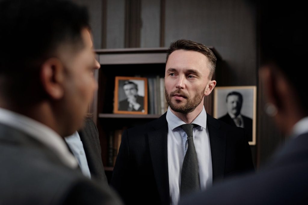 Group of men in suits having a serious business discussion in a professional setting.